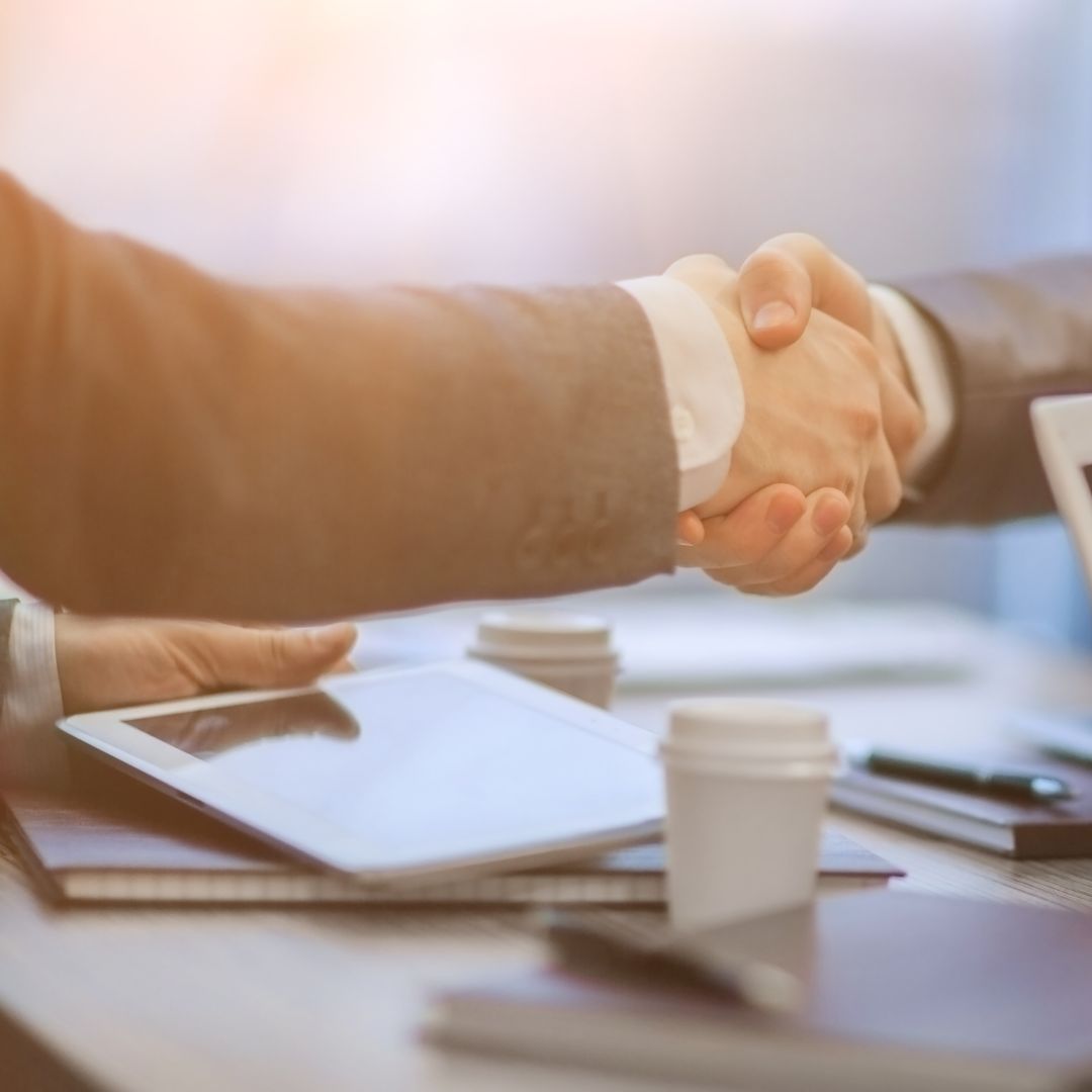 Shaking hands over desk